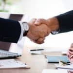 two real estate investors shaking hands over closing a deal